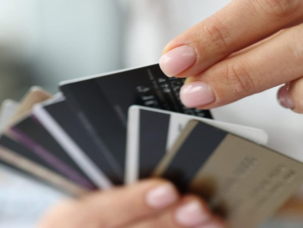 a woman's hands with multiple credit cards in them